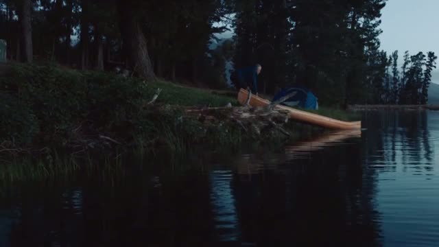 Man putting canoe is water
